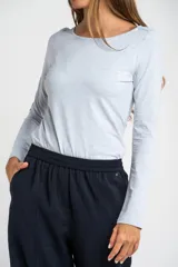Remera de manga larga ajustada al cuerpo, con cuello redondo, confeccionada en una mezcla de algodón y elastano que aporta suavidad y elasticidad.