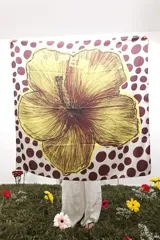 Pañuelo cuadrado de seda con estampado de lunares bordó sobre fondo beige y una gran ilustración central de una flor en tonos amarillos y marrones.
