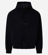 Campera con capucha de estilo urbano, confeccionada en sarga de algodón con efecto lavado. Presenta cierre frontal por cremallera, bolsillos tipo canguro, mangas largas con puños ajustados y bajo elástico. Incluye forro interior de poliéster.