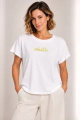Remera blanca de manga corta con cuello redondo y diseño holgado, con la palabra "chill" bordada en color verde en el centro del pecho.