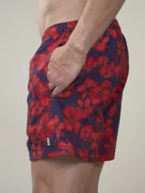 Short de baño con estampado botánico en tonos naranja y coral, con cintura elástica ajustable mediante cordón y malla interior para mayor soporte.