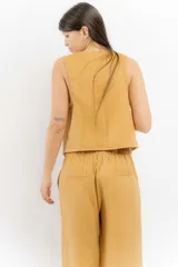 Chaleco de lino color bordó con escote en V y cierre frontal de botones. Presenta costuras a contratono y un diseño liviano ideal para el verano.