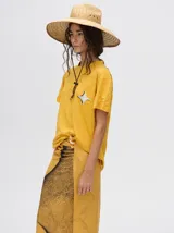 Pareo largo de viscosa en color verde menta, con diseño estampado que presenta gráficos abstractos y una figura central destacada en negro. Es una prenda liviana y fresca, ideal para usar sobre el traje de baño o como falda envolvente.