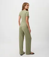Pijama largo de dos piezas color verde oliva con estampado a rayas. Incluye una remera de manga corta con escote en V y fruncido en el centro del busto, y un pantalón de corte recto con cintura elástica y cordón ajustable.