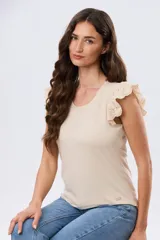 Remera de algodón color beige, de manga corta con volados de broderie, escote redondo y cuerpo liso.