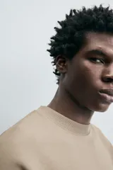 Sudadera de manga corta color marrón oscuro, con cuello redondo y bajo acabado en rib. Presenta un corte relajado y holgado (boxy fit).