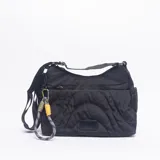 Bandolera de nylon color negro con diseño acolchado de líneas curvas. Cuenta con correa ajustable, cierre principal y un mosquetón decorativo con cordón trenzado en colores gris, amarillo y blanco.