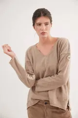 Buzo de escote en V y manga larga, confeccionado en lana lambswool. Presenta un diseño básico con detalle de raya en contratono en una de las mangas, puños y ruedo en color contrastante, y pin metálico de la marca aplicado en la manga.