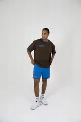 Short deportivo azul con ribete marrón y logo bordado en el muslo.