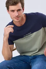 Remera de manga corta con diseño bicolor en azul marino y verde militar, con cuello redondo y estampa frontal con texto.