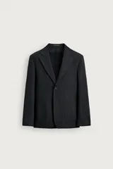 Blazer de corte relaxed fit confeccionada en tejido estructurado con algodón, color negro. Cuenta con cuello con solapas de muesca, cierre frontal de un botón, bolsillos de parche en la cadera y aberturas en la espalda.