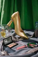 Zapato de tacón plateado, con punta fina y taco con forma de esfera.