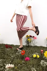 Falda corta de diseño versátil, confeccionada en tejido elástico con estampado de rayas verticales en tonos amarillo y bordó. Presenta un corte ajustado y adaptable que permite su uso como prenda superior o inferior.