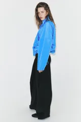 Pantalón de tiro alto con diseño cruzado tipo pareo en el frente, pernera ancha y caída fluida.