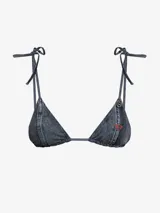 Sujetador de bikini tipo triángulo, confeccionado en tela denim gris oscuro, con tirantes finos ajustables para atar en cuello y espalda. Presenta un dije metálico con logo en el tirante derecho y una pequeña etiqueta roja en el lateral de la copa derecha.