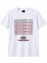 Remera blanca de manga corta, con cuello redondo y estampado frontal con el texto "BROOKLYN" repetido y "1987".
