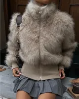 Campera de piel sintética con cuello alto y cierre frontal, combinada con una base de tejido de punto en la cintura y puños.