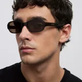Lentes de sol inspirados en los años 90, con armazón rectangular de bordes redondeados color marrón translúcido y lentes polarizadas en tono marrón.