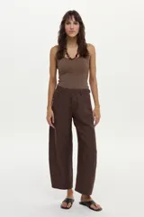 Pantalón marrón de tiro medio, con calce barrel de pierna redondeada y bolsillos laterales.