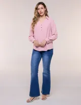 Blusa verde de calce holgado y caída fluida, confeccionada en tejido tipo crepé. Cuenta con cuello camisero con solapa, escote en V y cierre parcial al frente con tres botones metálicos. Las mangas son largas con puños abotonados.