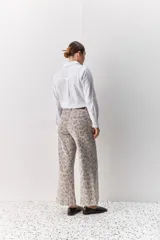 Pantalón de jean tiro medio con corte wide leg y estampado animal print. Presenta costuras verticales frontales y diseño de pierna amplia.
