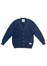 Cardigan azul de lana merino con cuello en V, cierre con botones marrones y dos bolsillos frontales.