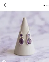 Caravanas de plata 925 con diseño colgante compuesto por dos piedras amatistas facetadas en engarce de plata.