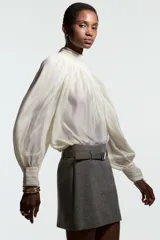 Pollera mini de tiro alto en color gris jaspeado, con diseño estructurado y cinturón extraíble con hebilla metálica rectangular.