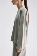 Remera de manga larga color gris verdoso, de calce relajado, con cuello redondo y mangas amplias.