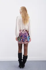 Falda corta tipo mini confeccionada en lentejuelas multicolor con base oscura. Presenta un diseño ajustado y forro interior.