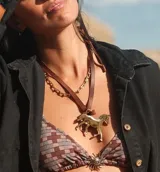 Collar con dije de caballo en bronce, montado sobre una tira de cuero marrón.