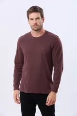 Remera de manga larga con cuello redondo, confeccionada en tejido de algodón. Presenta un pequeño logo bordado en el pecho y puños elásticos en las mangas.