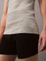 Pack de tres musculosas de algodón puro con cuello redondo y diseño sin mangas. Cada prenda presenta un corte clásico y un pequeño logo monograma bordado en el dobladillo inferior.
