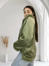 Campera verde de pana con cuello y puños de corderito. Cierre frontal con cremallera.