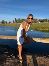 Vestido corto blanco tejido en hilo de algodón, con detalles de crochet en contraste negro en el cuello, sisas y ruedo.