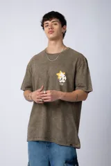 Remera de algodón con efecto acid wash en color gris oscuro. Presenta un diseño estampado en el pecho con una estrella amarilla y un personaje animado, y un corte semi-oversize.