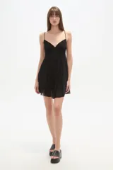 Vestido corto negro de tirantes finos, con escote en V profundo y diseño fluido con caída suave.