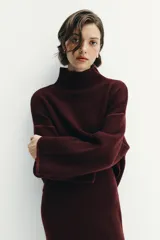 Jersey de punto color bordó con cuello subido, manga larga y diseño de corte holgado con costuras caídas en los hombros.