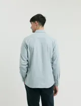 Camisa de tejido Oxford con cuello button-down, manga larga y bolsillo frontal. Presenta botones al tono y un corte clásico.