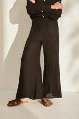 Pantalón ancho negro de lino con cintura elástica y detalles de flecos en los laterales.