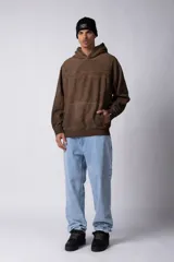 Buzo canguro de frisa gruesa con capucha, diseño oversize y acabado con efecto gastado. Presenta recortes horizontales en el frente y puños con elástico.