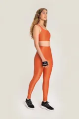 Calza deportiva naranja de tiro alto.
