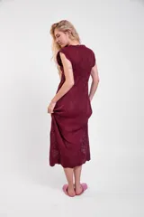 Vestido largo de crochet color crudo, con mangas cortas con volados y aberturas laterales, confeccionado en tejido calado de algodón con diseño ornamentado.
