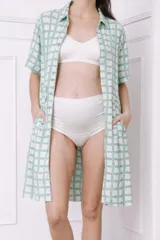 Camisa maternal de viscosa suave y liviana, con estampado de rayas verticales amarillas y blancas. Presenta cuello camisero, mangas cortas y bolsillos prácticos.