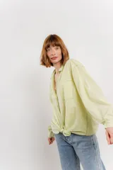 Camisa color crema de algodón con cuello camisero, botones y detalles de encaje en el escote.