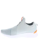 Championes Puma modelo Remedie Slip Strap, de diseño sin cordones con banda elástica cruzada en el empeine. Presenta una combinación de colores gris y gris topo con detalles en rosado, incluyendo el logo de la marca. Cuenta con una suela blanca de alto confort.