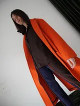 Tapado largo color verde con solapas, bolsillos laterales y cierre con botones.