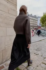 Cazadora de corte corto y diseño estructurado, confeccionada en tejido de paño color marrón. Presenta cuello subido, manga larga, bolsillos delanteros de plastrón con solapa y cierre frontal con cremallera oculta y botones a presión.