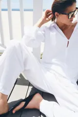 Camisa blanca de la colección ZARA Woman, confeccionada en hilatura con lino, con escote en pico, manga larga con puño ancho y detalles desflecados en cuello y bajo.