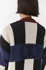 Cardigan de punto con diseño de bloques de color en tonos marrón, beige y verde. Presenta cuello redondo, cierre frontal con botones, mangas largas con hombros caídos y logo bordado en el frente.